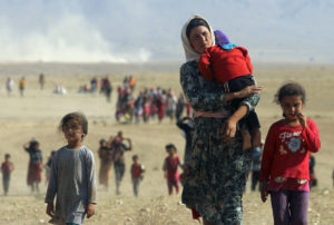 Displaced people from the minority Yazidi sect, fleeing violence from forces loyal to the Islamic State in Sinjar town, walk towards the Syrian border, on the outskirts of Sinjar mountain, near the Syrian border town of Elierbeh of Al-Hasakah Governorate August 11, 2014. Islamic State militants have killed at least 500 members of Iraq's Yazidi ethnic minority during their offensive in the north, Iraq's human rights minister told Reuters on Sunday. The Islamic State, which has declared a caliphate in parts of Iraq and Syria, has prompted tens of thousands of Yazidis and Christians to flee for their lives during their push to within a 30-minute drive of the Kurdish regional capital Arbil. Picture taken August 11, 2014. REUTERS/Rodi Said (IRAQ - Tags: POLITICS CIVIL UNREST TPX IMAGES OF THE DAY) FOR BEST QUALITY SEE RTR43BMZ - RTR426FA